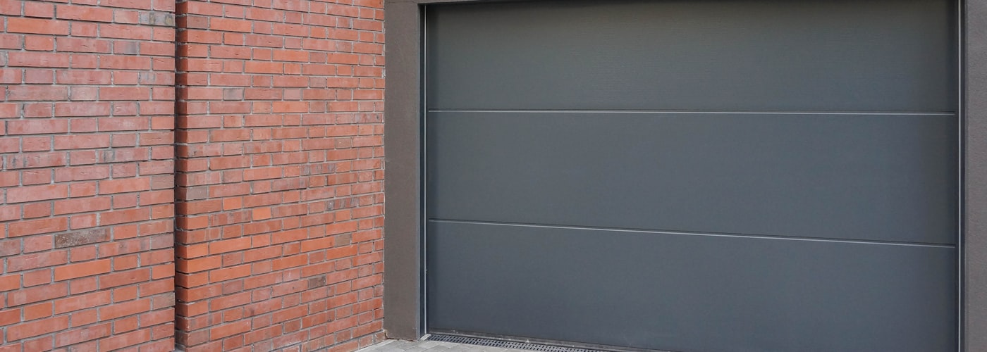 Modern steel garage door on a brick home